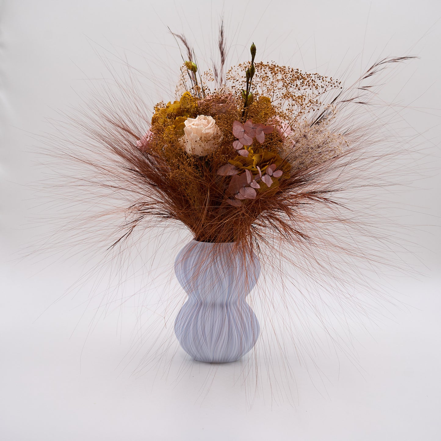 Vinrose bordeaux og lilla buket i en vase